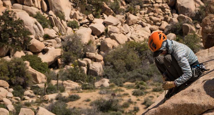 a person wearing a helmet rests on a rock during a gap year course with outward bound